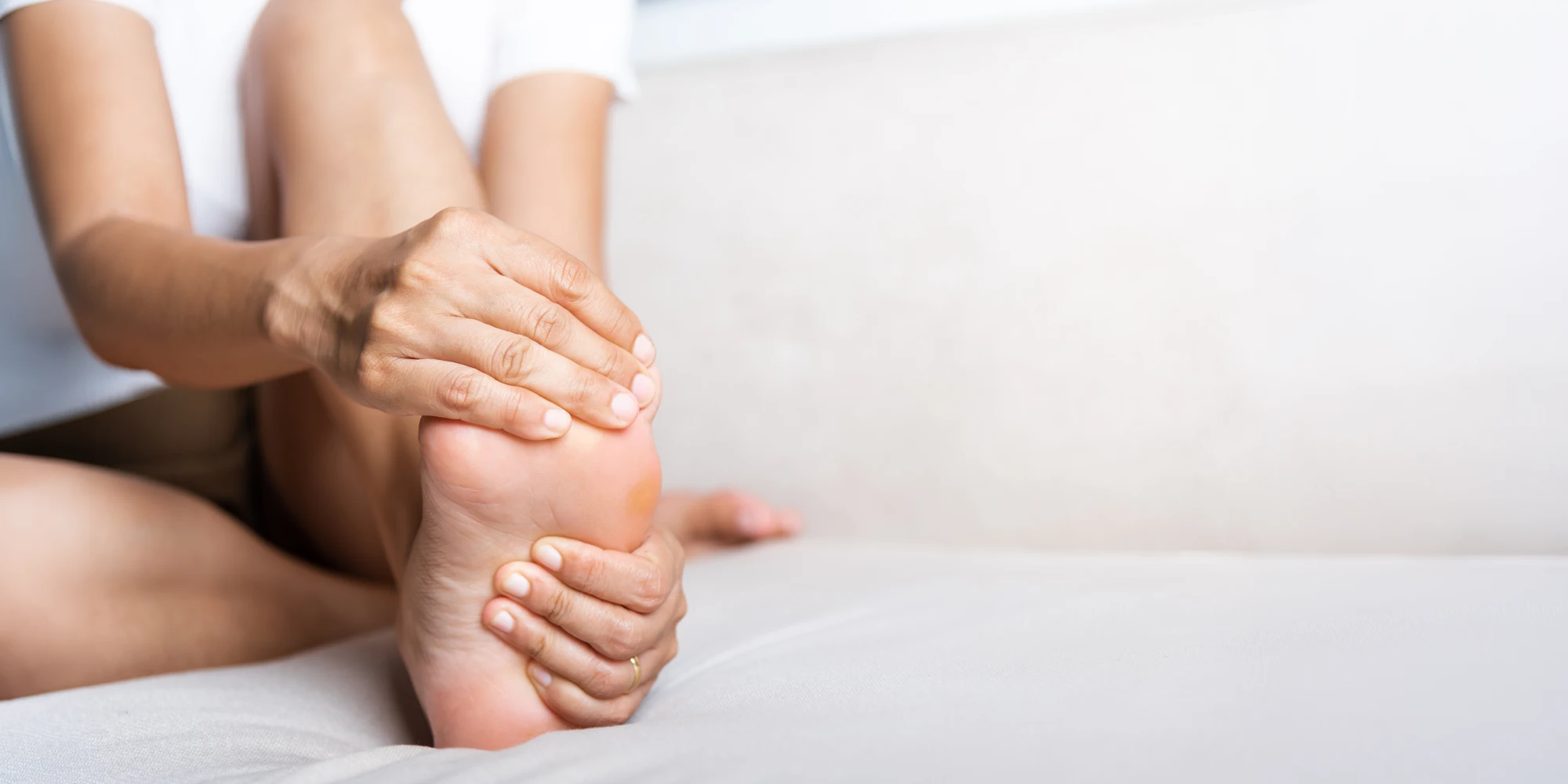 Woman Holding Her Foot In Pain